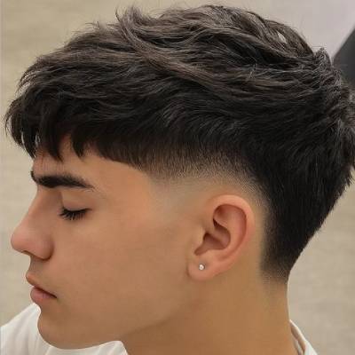 Short mullet hairstyle with textured top and clean fade on the sides, offering a modern and stylish look for men.