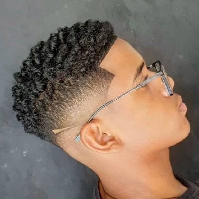 Sponged curls hairstyle with a clean fade on the sides and sharp lines, creating a defined and modern look, paired with glasses.