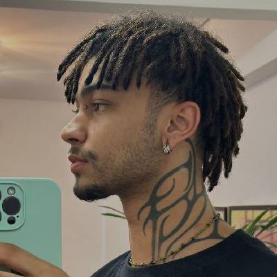 Stylish dreadlocks hairstyle with medium-length locks, paired with a neck tattoo, showcasing a modern, edgy look for men.